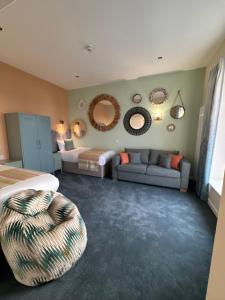 a bedroom with a bed and a couch and mirrors at Balmoral Hotel in Blackpool