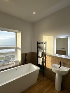uma casa de banho com uma banheira, um lavatório e uma janela em Balmoral Hotel em Blackpool