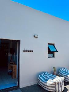 two bean bag chairs in a room with a white wall at Lower Point Surf Studio in Jeffreys Bay