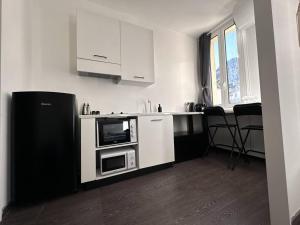 a kitchen with white cabinets and a microwave at NEW Studio, 2mn walk to Monaco in Beausoleil