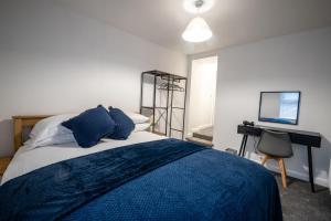 a bedroom with a bed and a desk and a television at Seaside Apartments in the Centre of Morecambe in Morecambe
