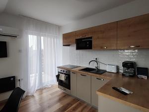 a kitchen with a sink and a stove top oven at Lokomotív Apartman in Balatonmáriafürdő