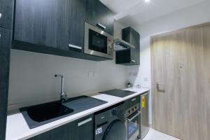a kitchen with a sink and a washing machine at Chic Studio Underdog in Accra