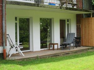 eine Veranda mit zwei Stühlen und einer Bank darauf in der Unterkunft Ferienwohnung Gieske - Wollmann in Westerholz