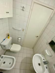 a white bathroom with a toilet and a sink at 3 Amb. C/Cochera Zona “La Perla” in Mar del Plata
