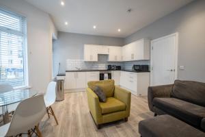 a living room with a couch and a chair and a table at Seaside Apartments in the Centre of Morecambe in Morecambe