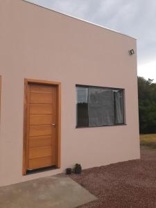 um edifício com uma porta e uma janela em Suítes Flor do Maracujá 02 em Ponta Grossa
