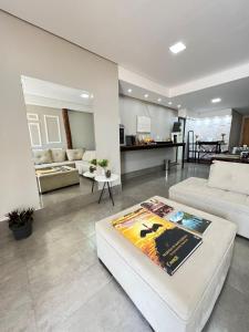 a living room with a white couch and a table at POUSADA DA MAGA in Chapada dos Guimarães