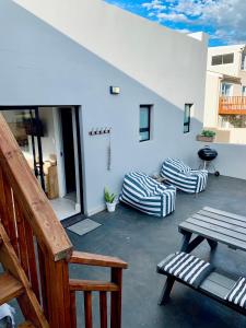a patio with a bench and chairs on a building at Lower Point Surf Studio in Jeffreys Bay