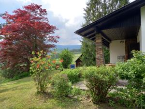 a tree with red leaves next to a house at Ferienhaus Hölzl in Trog