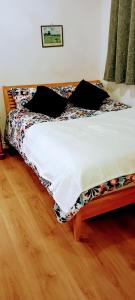 uma cama num quarto com piso em madeira em Aaron's Holiday Home em Belfast