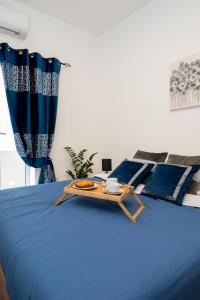 un letto blu con un vassoio di cibo sopra di Chic 1BR Retreat in St Julian's a San Giuliano