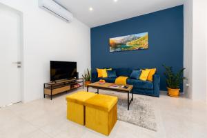 un soggiorno con divano blu e TV di Chic 1BR Retreat in St Julian's a San Giuliano