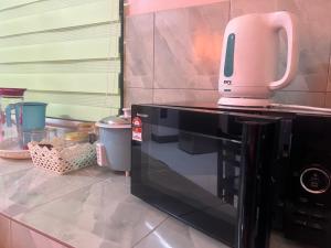 a pink appliance sitting on top of a microwave at Nuha's Homestay Teluk Intan in Teluk Intan