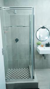 a shower with a glass door in a bathroom at Omi’s Wholesome Apartment in Mthatha +15 photos