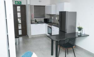 a kitchen with a black counter and a refrigerator at Omi’s Wholesome Apartment in Mthatha