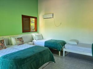 een ziekenhuiskamer met 2 bedden en een raam bij Pousada Maliale Boipeba in Ilha de Boipeba