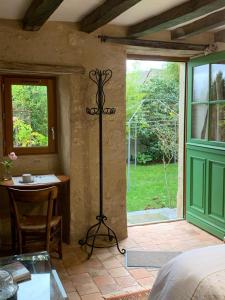 una camera con letto, tavolo e finestra di Capucine a Noyen-sur-Sarthe