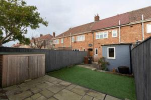 a backyard of a house with a fence at Carrick House in Hartlepool