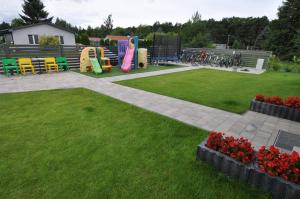 a park with a playground with colorful chairs and flowers at APARTAMENTY POD ŻAGLAMI MIELENKO in Mielenko