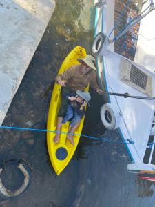 Nile View Guest House في أسوان: رجل وولد في قوارب الكاياك الصفراء على متن قارب