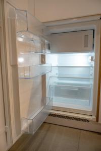 an empty refrigerator with empty shelves in a kitchen at Raspberry apartment and SPA in Dziwnów