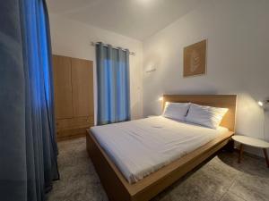 a small bedroom with a bed with blue curtains at PebBle Apartments in Marathias
