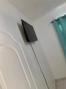 a television sitting on a wall next to a window at Apartamento segundo piso B in Santa Cruz de Barahona