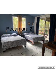 a bedroom with two beds and a window at Casa en Juan Angel Ver in Chachalacas