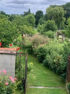 un jardín con una puerta en la hierba y flores en Capucine, en Noyen-sur-Sarthe