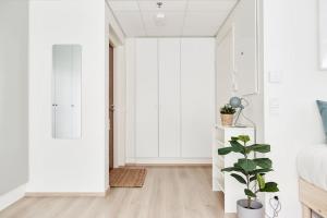 een slaapkamer met witte muren en een plant bij Beautiful apartment in the center of Tampere in Tampere