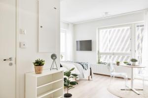 een witte slaapkamer met een bed en een tafel bij Beautiful apartment in the center of Tampere in Tampere