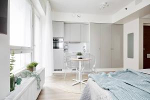 a bedroom with a bed and a table and a kitchen at Beautiful apartment in the center of Tampere in Tampere