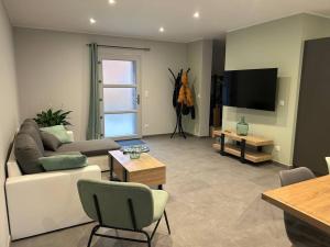 a living room with a couch and a flat screen tv at Gite La Cuisance 