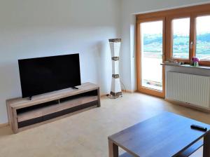 a living room with a flat screen tv on a entertainment center at Genuss Appartement am Familien Weingut in Krottendorf bei Ligist