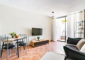 a living room with a table and a tv at Cosy Apartment in Los Cristianos 5min to the ocean in Los Cristianos