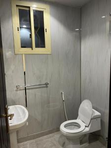 La salle de bains est pourvue de toilettes et d'un lavabo. dans l'établissement هابي دريم للشقق المخدومة, à Ukaz