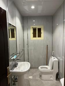 a bathroom with a white toilet and a sink at هابي دريم للشقق المخدومة in Ukaz