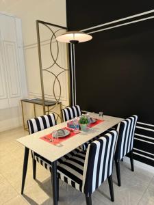 a dining room table with striped chairs and a blackboard at Axon Residence By Classy 1 minutes Pavilion in Kuala Lumpur