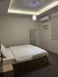 ein Schlafzimmer mit einem Bett in einem Zimmer in der Unterkunft هابي دريم للشقق المخدومة in Ukaz