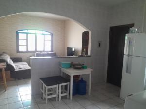 uma cozinha com uma mesa e um frigorífico branco em Cass Praia em Solemar