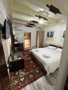 ein Schlafzimmer mit einem großen weißen Bett und einem Teppich in der Unterkunft Zam-Zam Teracce in Buxoro