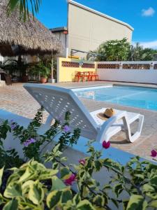 a white chair next to a swimming pool at Hotel Coronado Inn in Playa Coronado