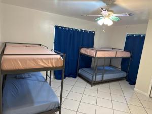 two bunk beds in a room with a ceiling fan at Hospedaje North Miami in North Miami