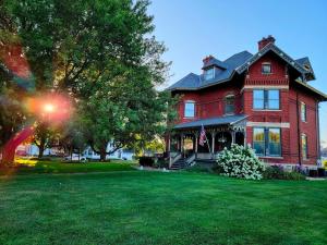 a red house with a flag on the front yard at Squiers 1882 in Maquoketa