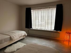 a bedroom with a bed and a large window at Budget Flex in Geel