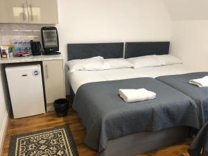 ein Schlafzimmer mit 2 Betten und Handtüchern darauf in der Unterkunft Callcote road Hotel in London