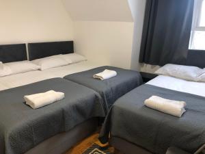 ein Zimmer mit 2 Betten und Handtüchern darauf in der Unterkunft Callcote road Hotel in London