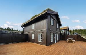 a black house with a deck with a table on it at 4 Bedroom Amazing Home In seral in Åseral