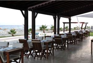 eine Reihe von Tischen und Stühlen mit dem Meer im Hintergrund in der Unterkunft Hotel Silvanus in Oren